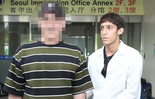 이란 난민 소년 김민혁 군의 아버지(왼쪽)가 11일 오후 서울 양천구 서울출입국외국인청 별관에서 난민 지위 재심사를 받는 중 잠시 청사를 나와 김민혁 군과 이야기를 나누고 있다.